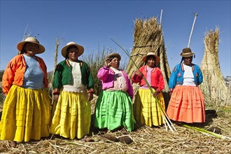 Peru, Puno, Lake Titicaca Women in colorful clothing on Grass Island. . 
Photo Richard Rickard /