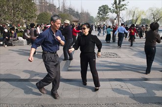 China, Jiangsu, Nanjing, Retired couples dancing beneath the Ming city wall at Xuanwu Lake Park