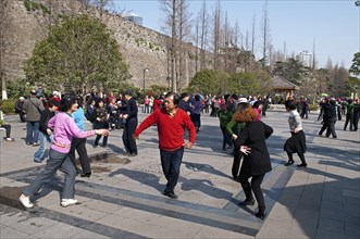 China, Jiangsu, Nanjing, Retired couples dancing beneath the Ming city wall at Xuanwu Lake Park Man