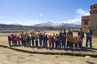 China, Szechuan Province, Tibet, School children waving outside their school. 
Photo Nic I Anson /
