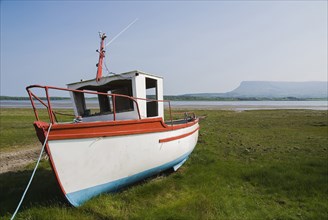 Ireland, County Sligo, Rosses Point, Boat moored on the 3rd beach with Ben Bulben in the background