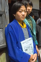 Bhutan, Mongar, Portrait of a Bhutanese school girl holding Social Studies textbook. 
Photo Nic