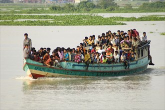 Bangladesh, Dhaka Division, Keraniganj Upazila, Overcrowded boat travelling down a tributary river.