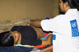 Bangladesh, Chittagong Division, Khagrachari, Pregnant mother being examined by UNDP nurse. 
Photo