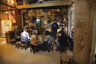 Turkey, Istanbul, Fatih, Sultanahmet, Kapalicarsi, Tourists sat at coffee shop in the Grand Bazaar.