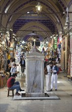 Turkey, Istanbul, Fatih, Sultanahmet, Kapalicarsi, Man washing his feet in the Grand Bazaar.