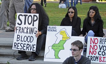 Canada, Alberta, Lethbridge, Three Blood Tribe members holding protest signs at anti-fracking