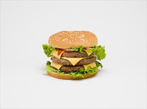 Food, Cooked, Meat Triple cheesburger with salad and tomato ketchup in a bun on a white background.