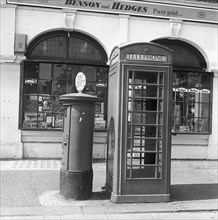 Cabine téléphonique et boîte aux lettres dans une rue de Londres, vers 1940