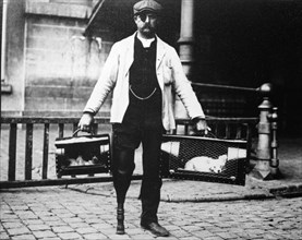 Dog market - Dog Seller with Wooden Leg and Eye Patch, photo by Andrew Pitcairn-Knowles. Brussels, c.1900