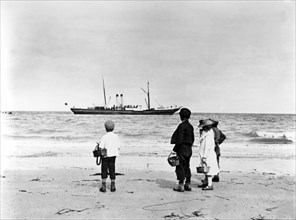 Enfants regardant au loin un bateau à vapeur