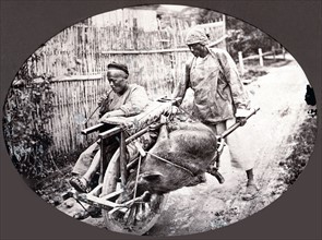 China, porter pushing a chair equipped with a wheel