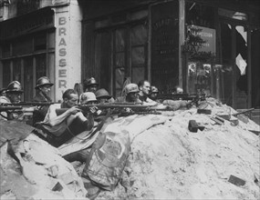 Des combattants des F.F.I. en embuscade rue de la Huchette à Paris, lors de la Libération (août 1944)