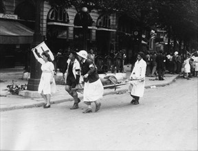 Groupe de brancardiers de la Croix-Rouge se rendant sur les lieux du combat, lors de l'insurrection de Paris (août 1944)