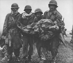 Groupe de soldats portant un camarade blessé, pendant la Guerre d'Algérie