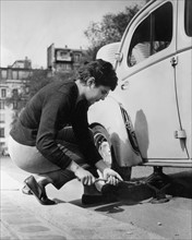 Woman changing the tire of her car