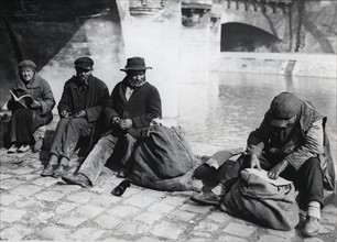 Homeless people enjoying the first spring days on the verge of the Seine