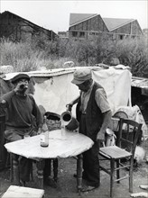 Two old men having a drink in the workers' gardens