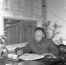 Pu Yi en train de lire le Journal du Peuple, 1959