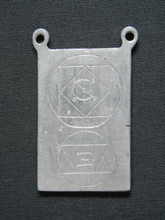 Lead amulet engraved with esoteric signs.