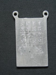 Lead amulet engraved with esoteric signs.