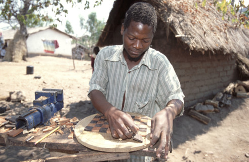 Man making a wooden chess board
\n