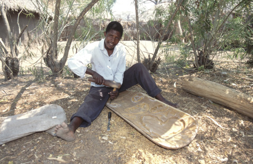 Man carving a woodern chair
\n