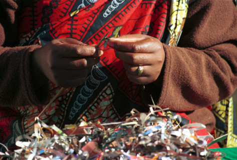 A Rwandan worker creates colourful beads from paper at Umtha Beads, a craft business run by David