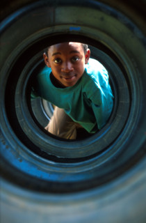 boy playing in a tyre