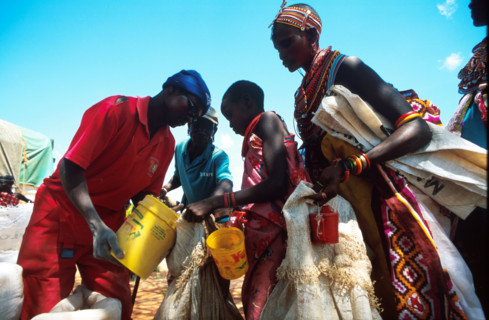Solomon Gitonga, an aid worker with EdFri International measures out grain for Samburu women and girls