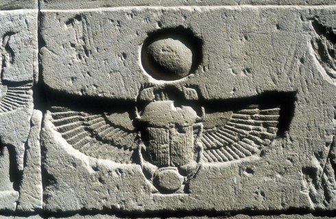 Scarab beetle and vulture wings under disk of the sun