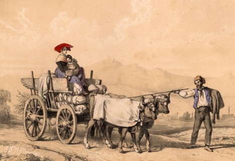 Woman and child in traditional dress riding on a cart full of sacks