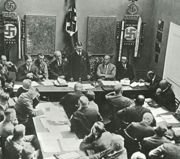 Hitler in Munich adressing a meeting of the NSDAP in 1925. Third to the left of Hitler is Alfred