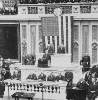 President Calvin Coolidge addressing the US Congress, Warren Harding is seated to the right of the Speaker