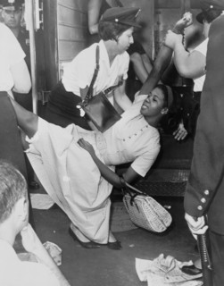 African American woman being carried to police patrol wagon during demonstration in Brooklyn