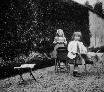 Two young French girls play in a garden