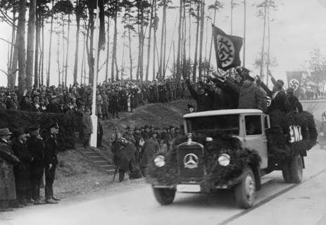 Men standing in the back of a truck salute Hermann Göring, 1936
