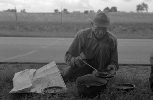Migrant agricultural worker dishing up the noonday lunch of blackberry pie while camped by the roadside east of Fort Gibson, Muskogee County, Oklahoma By Russell Lee, 1903-1986, photographer Date 1939...