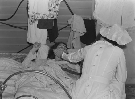 Nurse with patient at a Farm Security Administration (FSA) camp for migratory agricultural workers at Farmersville. 19380101