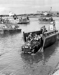 Photograph of a Jeep being rolled off a landing boat at Fedala harbour during the landing operations of the U.S. task forces