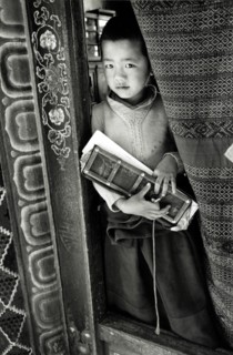 Photograph of a young boy holding a prayer book in Sikkim