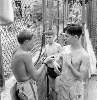 Glen Echo, Maryland, USA. An attendant washing the sand from people who are going to the swimming pool for the swimming pool at the Glen Echo amusement park.