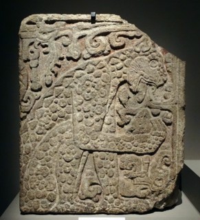 Mayan, calcified stone panel, with bas relief depicting a jaguar eating a heart.
