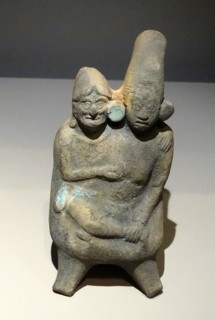 Mayan ceramic figurine of a young woman in the embrace of an old man.