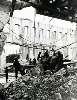 Troops inspecting pieces from grounded fighter plane