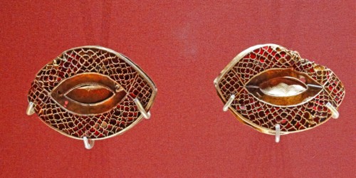 Anglo Saxon metalwork; 5th-6th Century AD. Pair of eye-shaped mounts, with cloisonné garnets