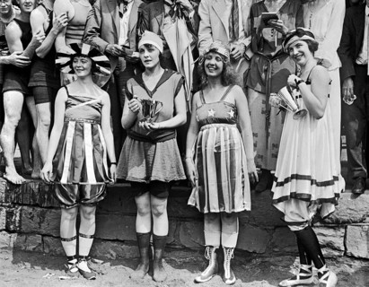 Photograph of young women wearing appropriate swimwear and holding trophies