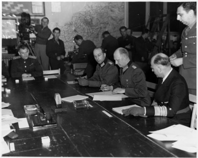 Photograph of Alfred Jodl signing a document of unconditional surrender