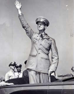 General Wainwright, standing in car, waving to crowd gathered at La Guardia