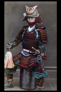 Hand-coloured photograph of a Japanese warrior or Samurai with body tattoos. Photographed by Felice Beato